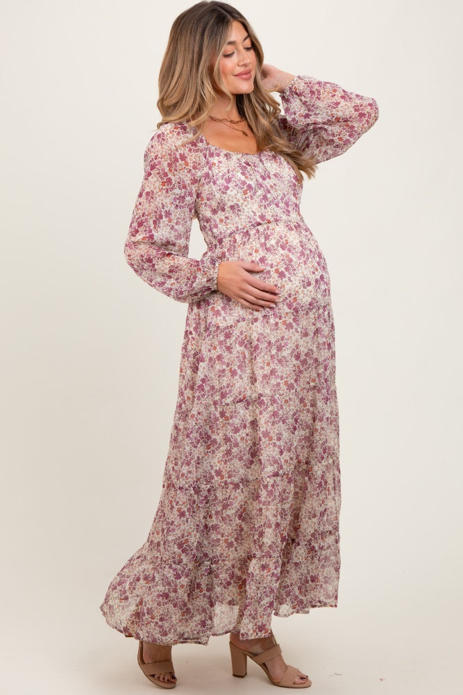 woman wearing a floral maternity maxi dress with long sleeves and a visible baby bump