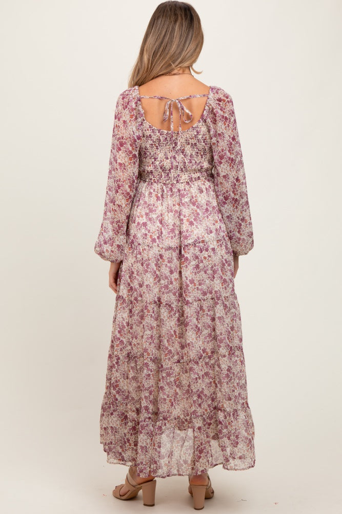 woman wearing a floral maternity maxi dress with long sleeves and an open back detail
