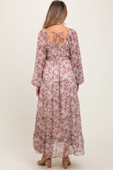 woman wearing a floral maternity maxi dress with long sleeves and an open back detail