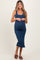 woman wearing a navy blue ribbed maternity dress that hugs her baby bump