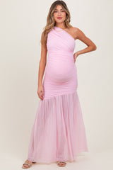 woman wearing a light pink one-shoulder maternity gown with tulle skirt and visible baby bump