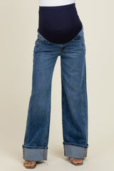 woman wearing blue wide-leg maternity jeans with a high waistband and cuffed hems, showing a pregnant belly
