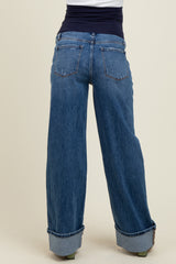 woman wearing light blue maternity jeans with a wide leg and folded cuffs, showcasing a stretchy black waist panel