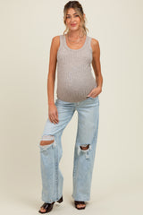 woman wearing a beige ribbed maternity tank top and distressed light wash jeans, showing a baby bump