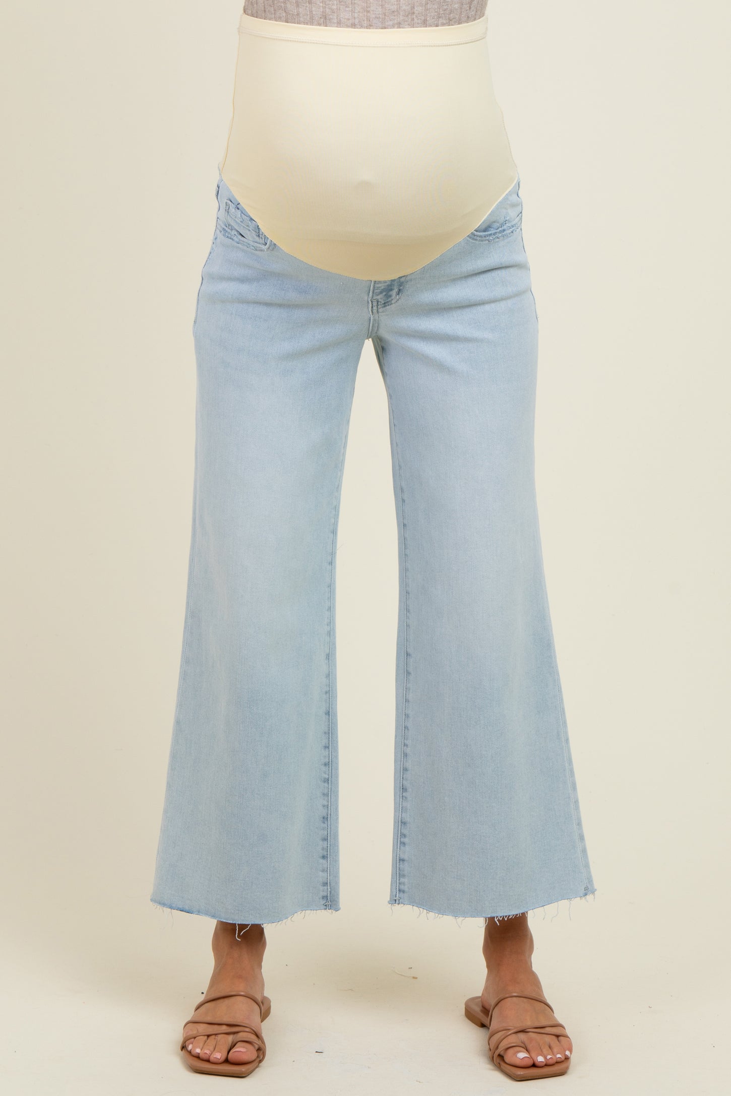 woman wearing light blue maternity wide-leg jeans with a stretchy beige belly panel