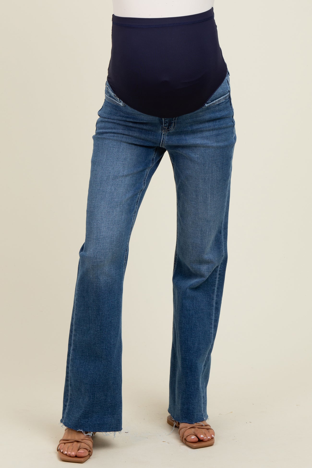woman wearing dark blue maternity jeans with a stretchy belly panel and flared legs