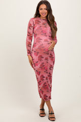 woman wearing a pink floral long sleeve maternity dress and holding her baby bump