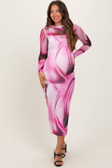 woman wearing a pink long sleeve maternity dress with a swirl design and a visible baby bump