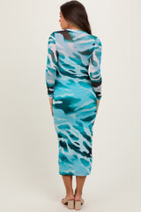 woman wearing a turquoise camouflage print long sleeve maternity dress, showcasing a fitted silhouette from the back