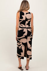 woman wearing a black and tan abstract patterned maternity dress with a back slit