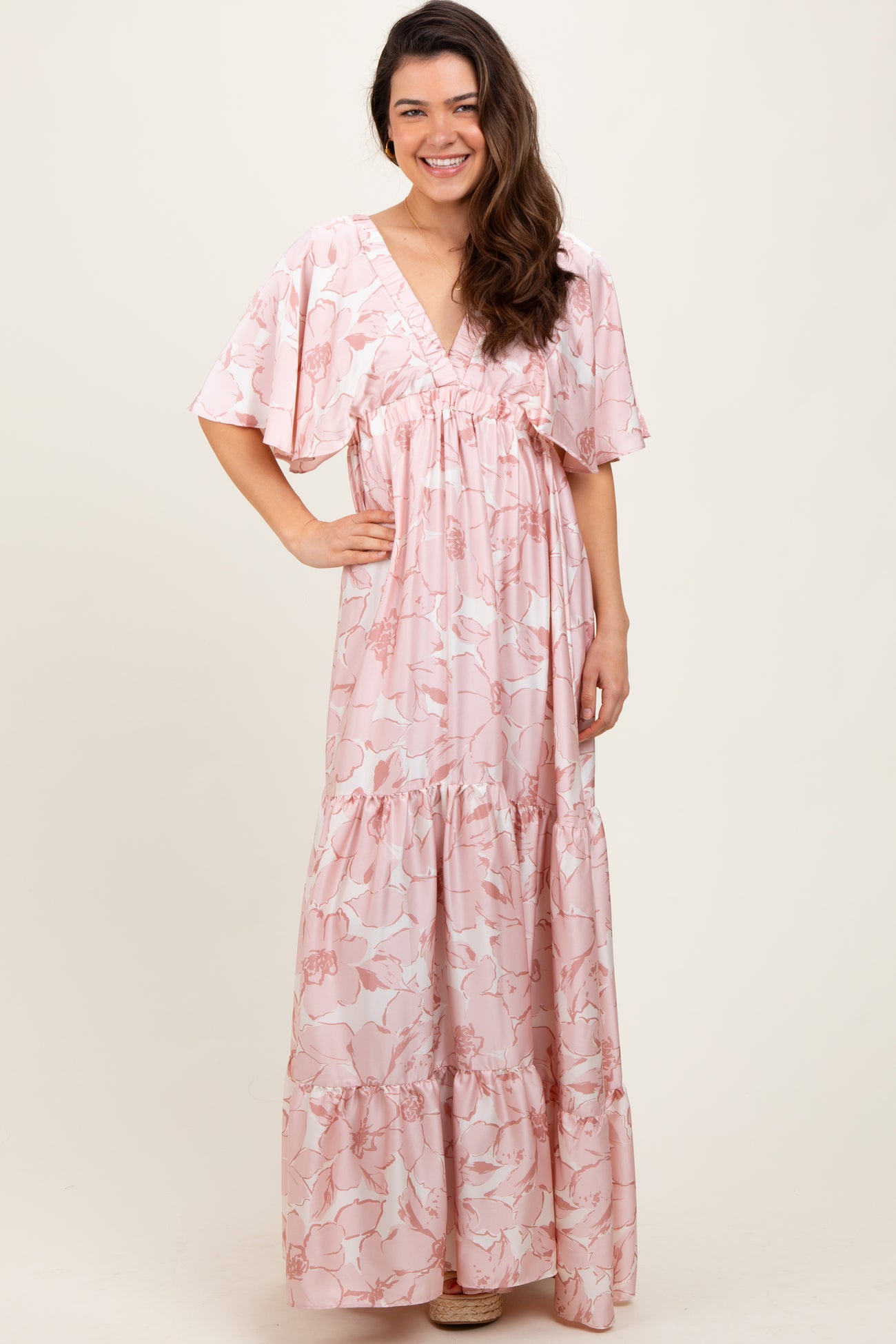 woman wearing a pink floral maxi dress with short sleeves and a tiered skirt