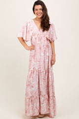 woman wearing a pink floral maxi dress with short sleeves and a tiered skirt
