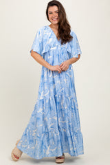 woman wearing a light blue floral maxi dress with tiered design and flutter sleeves