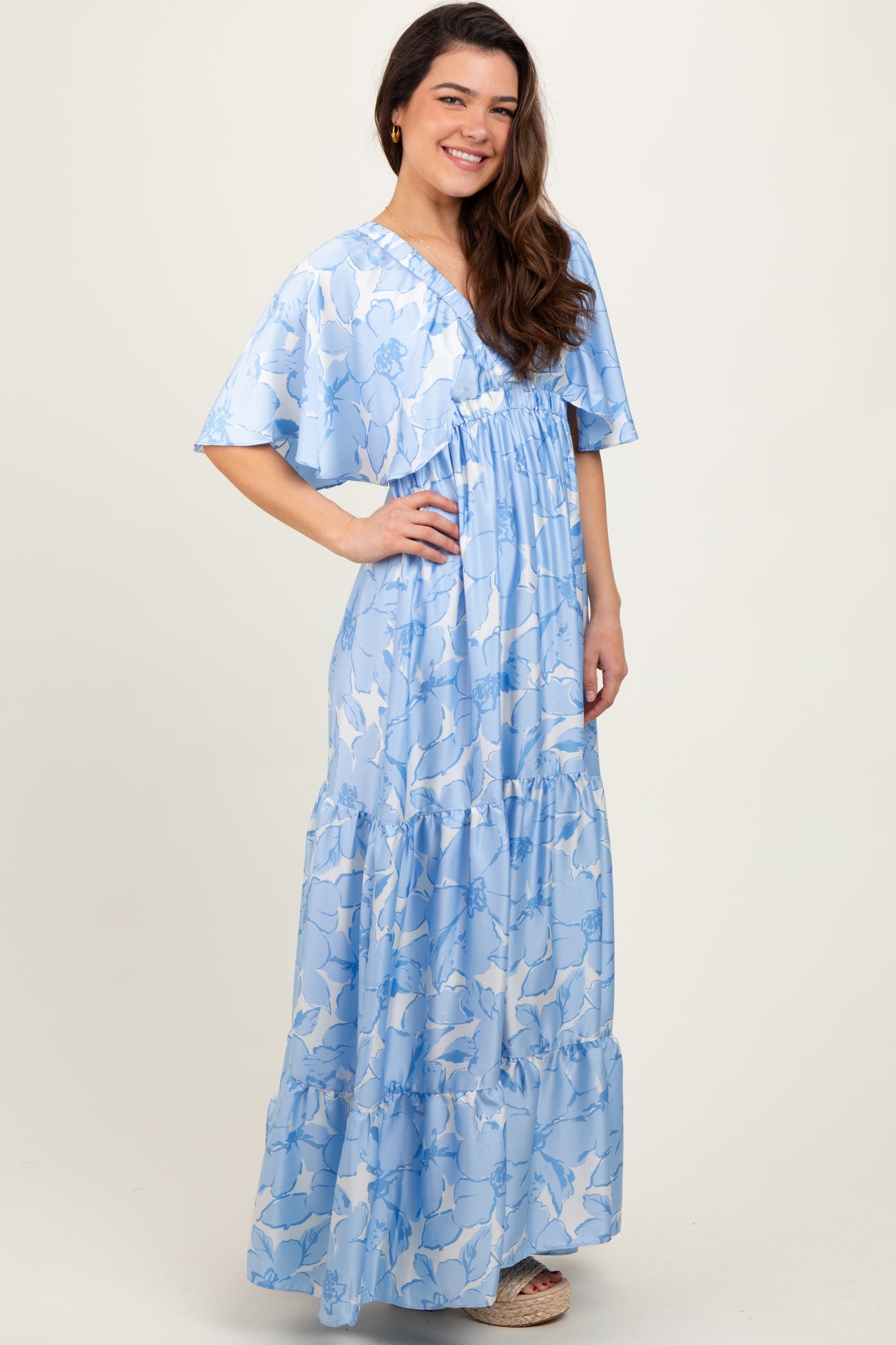 woman wearing a light blue floral maxi dress with a v-neckline and flutter sleeves