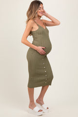 woman wearing a green ribbed maternity dress with buttons and showing her baby bump