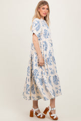 woman wearing a cream and blue floral print maxi dress with short sleeves and a tiered design