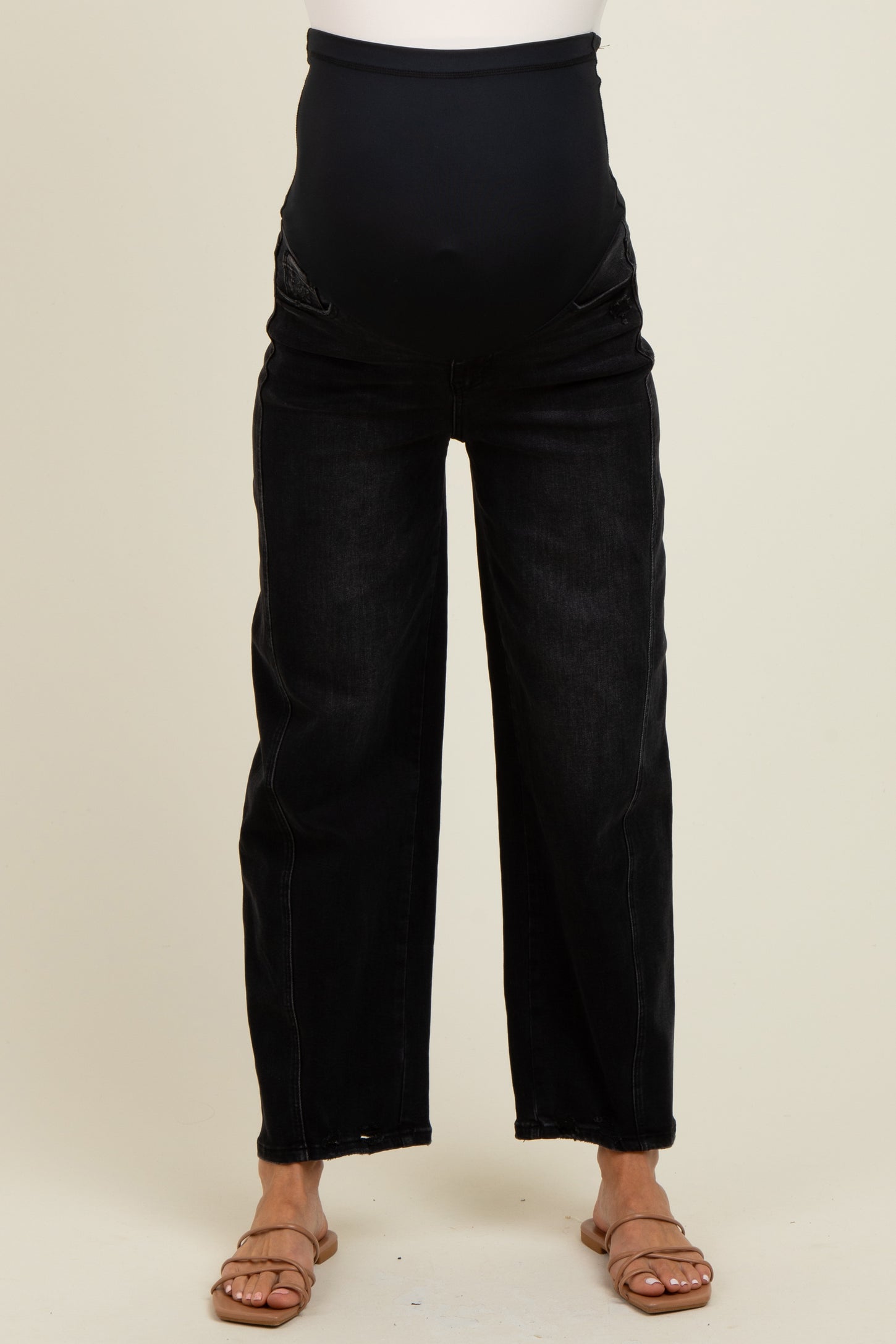 woman wearing black wide leg maternity jeans with a belly panel and a visible baby bump
