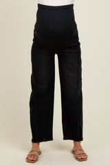 woman wearing black wide leg maternity jeans with a belly panel and a visible baby bump