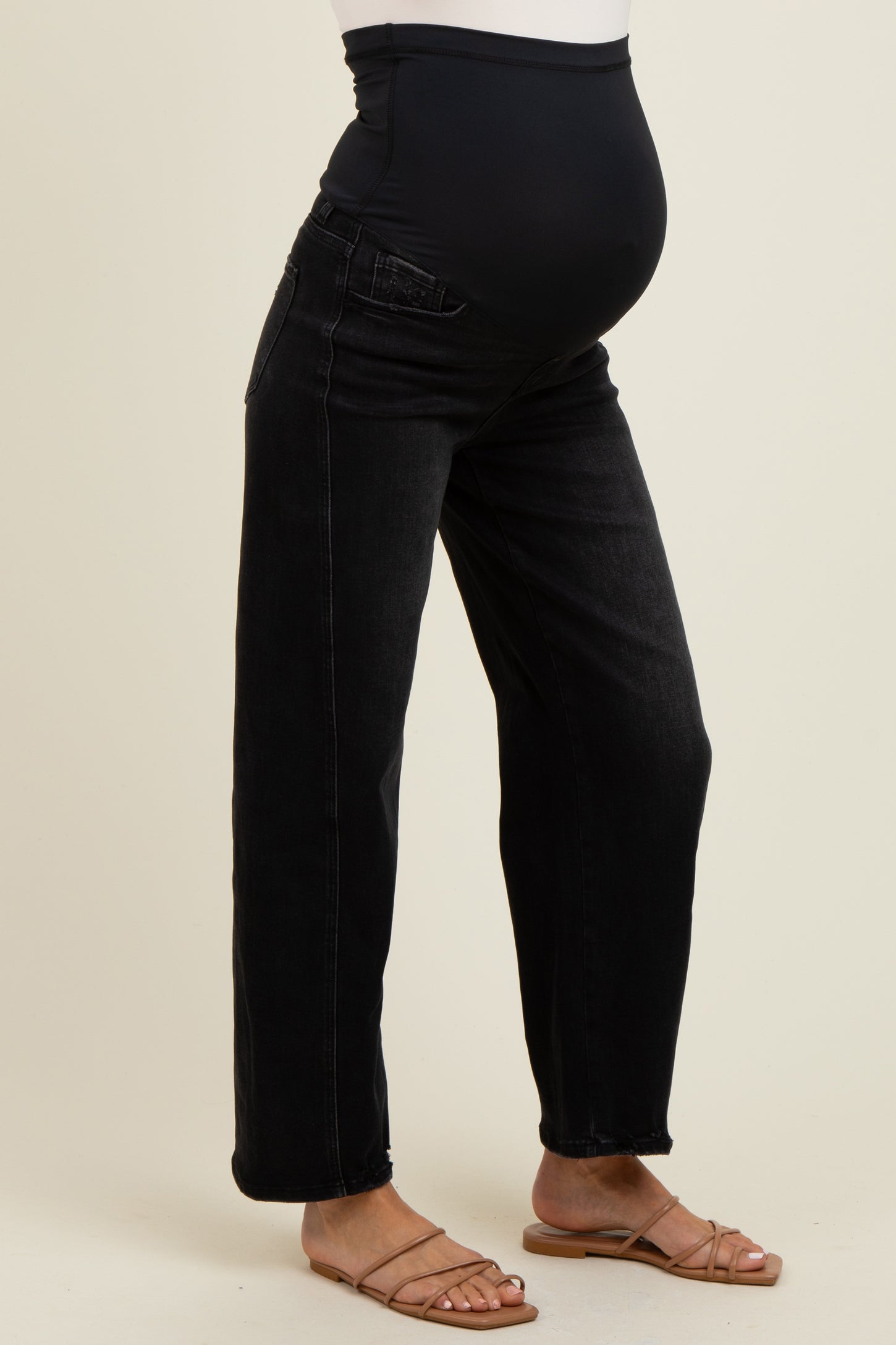 woman wearing black maternity jeans with a supportive waistband and a visible baby bump
