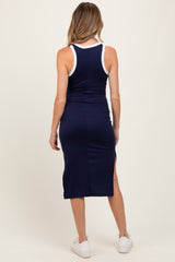 woman wearing a navy blue ribbed maternity midi dress with white trim and side slits, showing her back