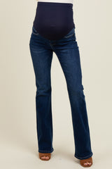 maternity wear dark wash flared jeans with a supportive belly panel, model standing and wearing heels