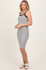 woman wearing a black and white striped fitted dress with spaghetti straps and white heeled sandals