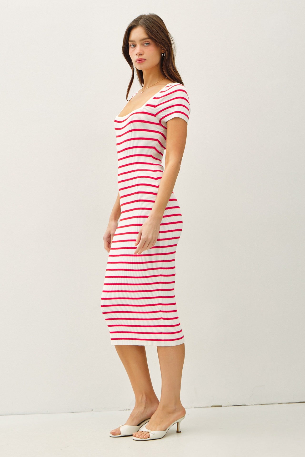 woman wearing a fitted midi dress with red and white stripes and short sleeves