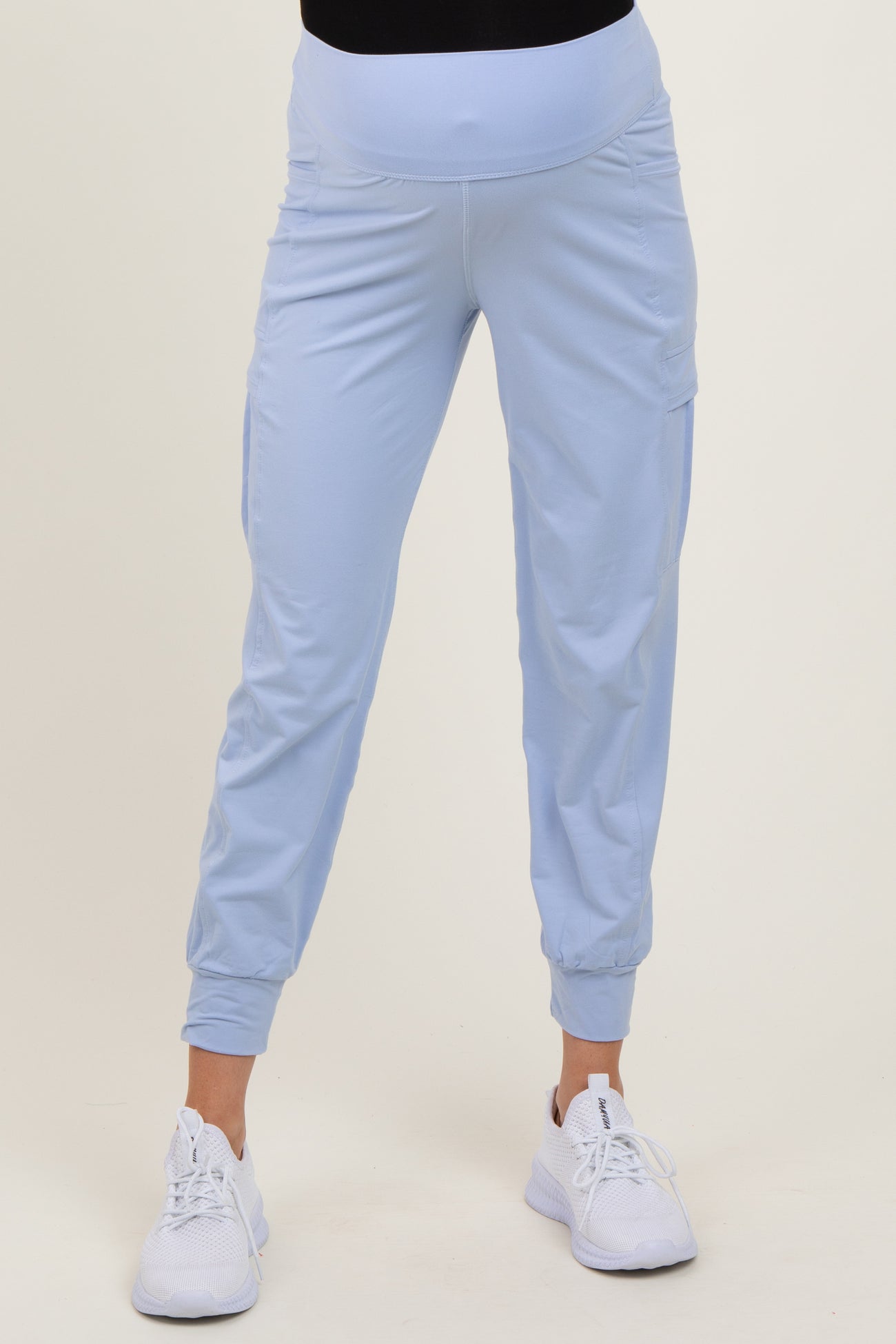 woman wearing light blue maternity jogger pants with a fitted waistband and side pockets