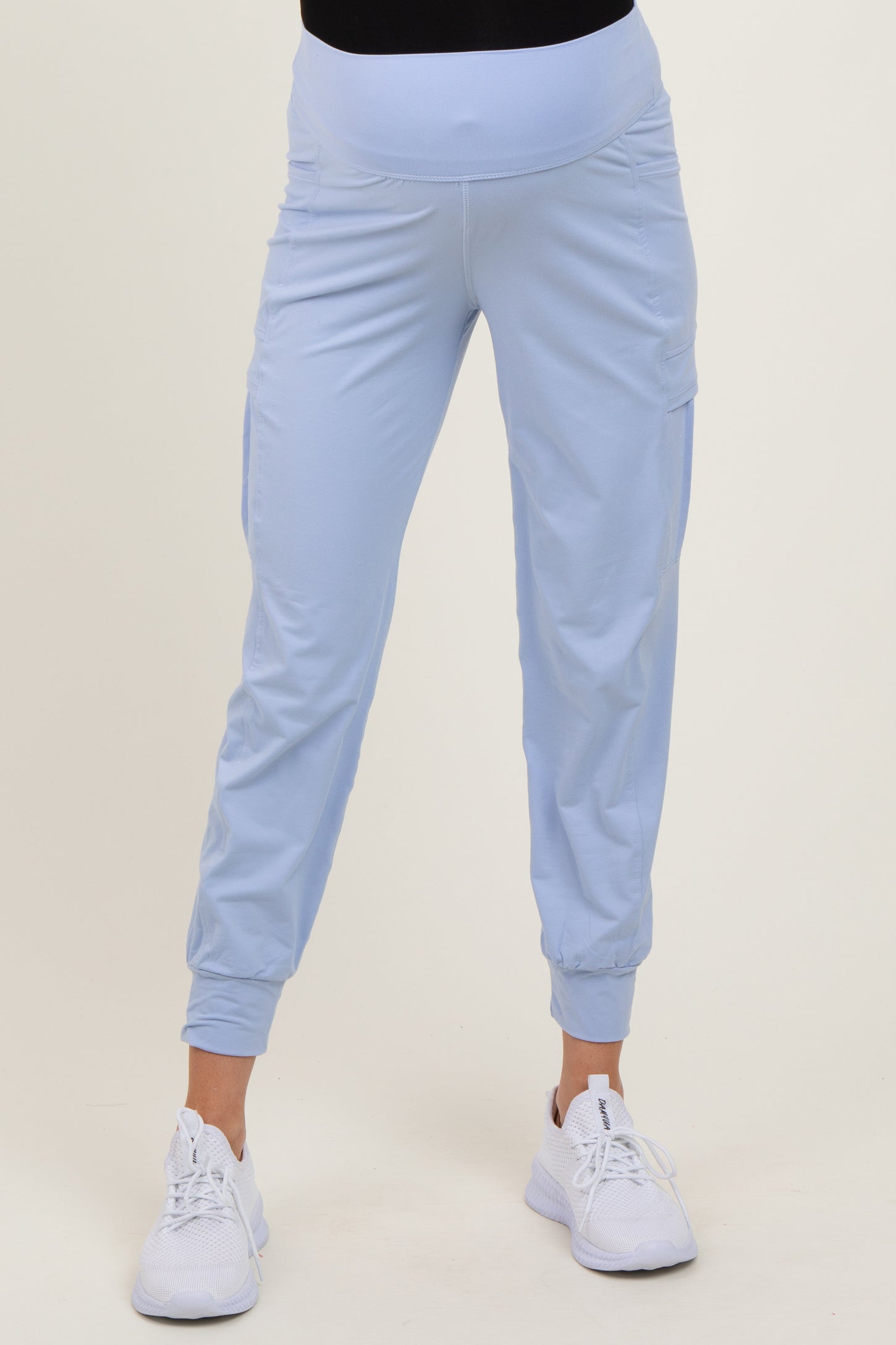 woman wearing light blue maternity jogger pants with a fitted waistband and side pockets