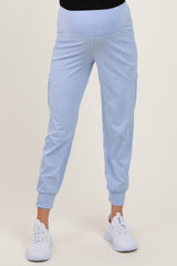 woman wearing light blue maternity jogger pants with a fitted waistband and side pockets