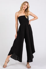 woman wearing a black strapless jumpsuit with a smocked bodice and wide-leg pants