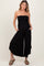 woman wearing a black strapless maternity jumpsuit with pockets and a flowing wide leg, showing a baby bump
