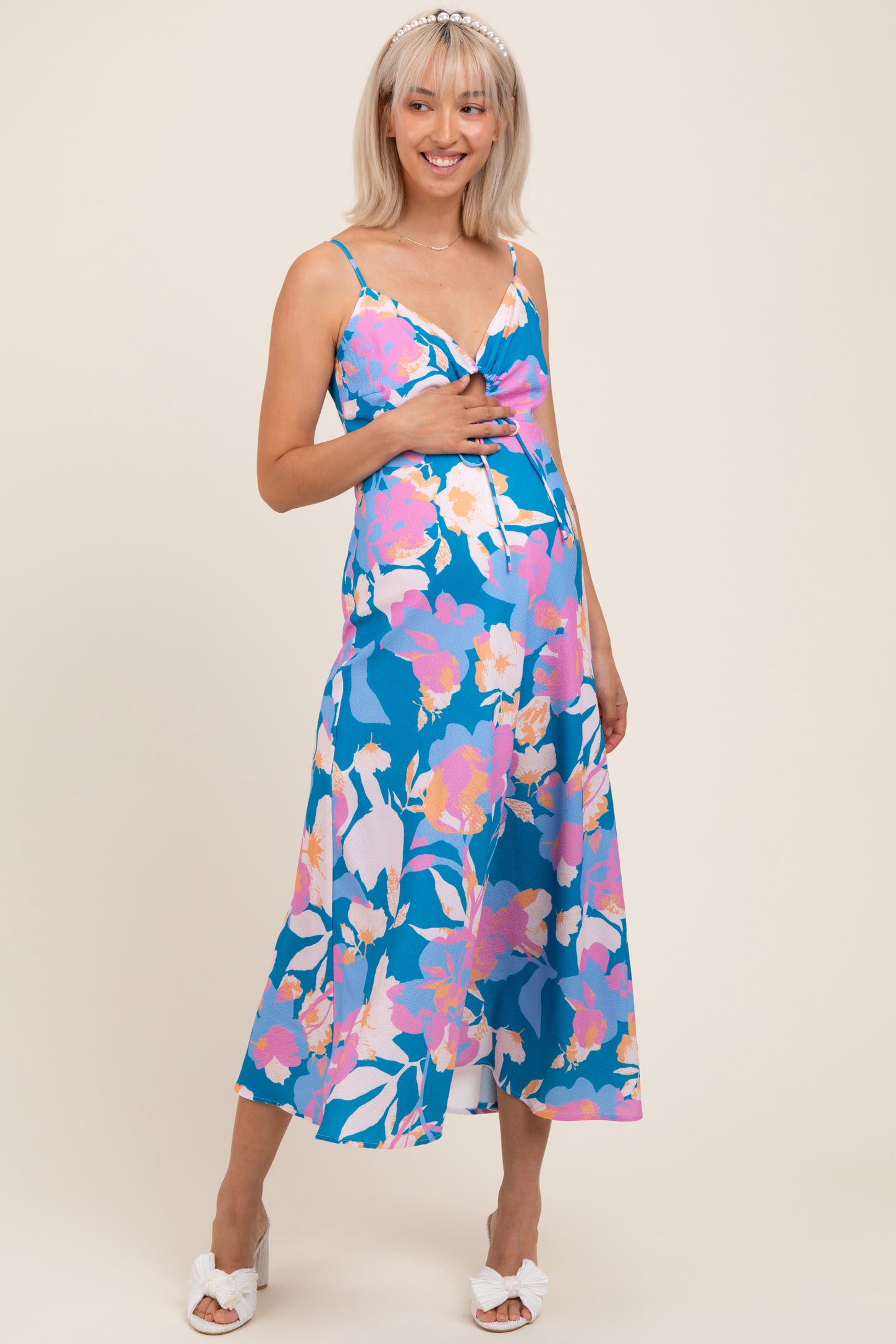 woman wearing a blue floral maternity dress with a sweetheart neckline and a visible baby bump