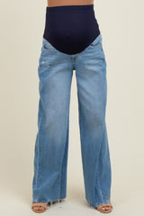 woman wearing light wash wide-leg maternity jeans with a dark blue over-the-bump waistband and distressed details