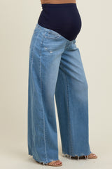 woman wearing light blue maternity wide-leg jeans with a navy belly panel and a visible baby bump