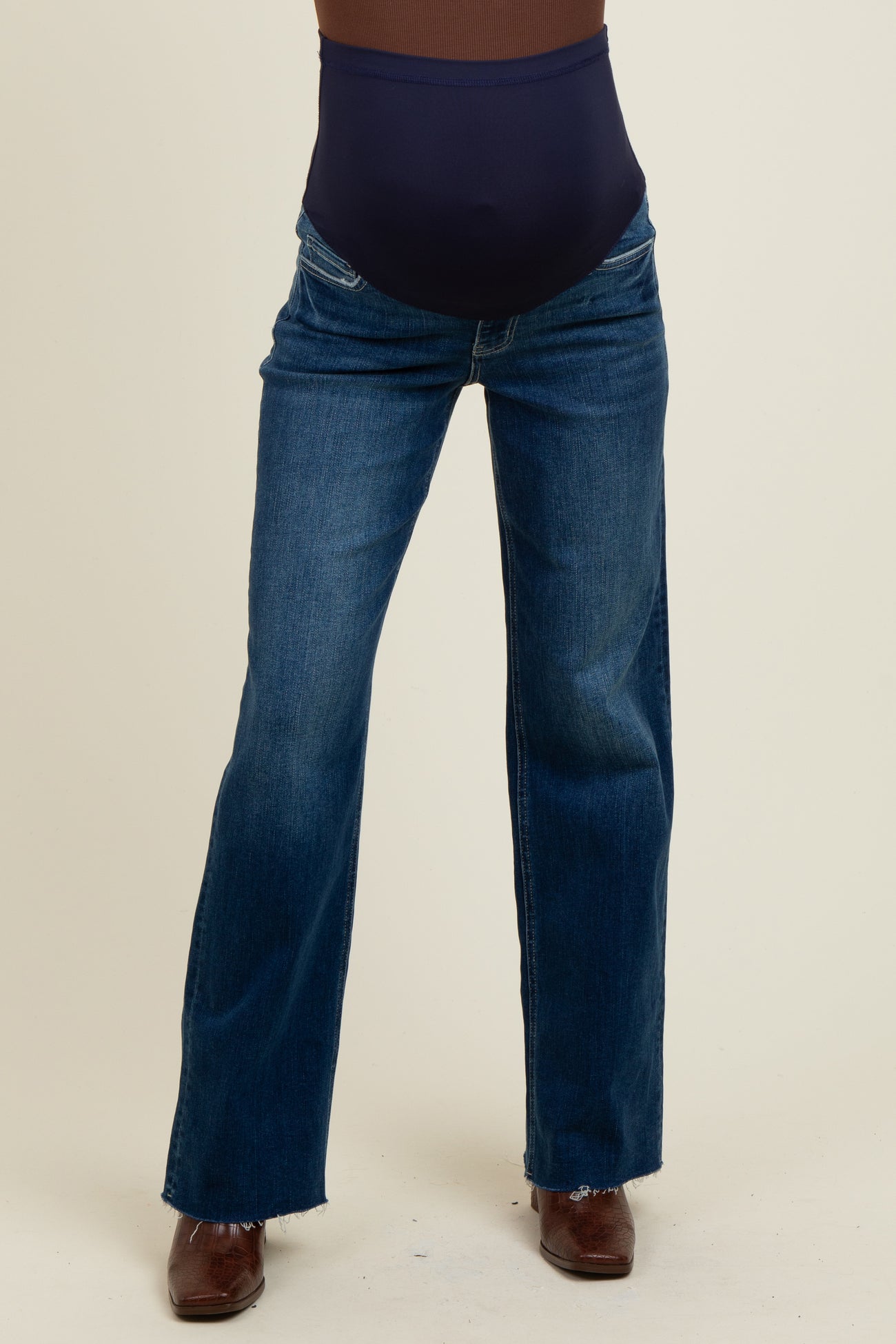 woman wearing a dark blue maternity bootcut jeans with a high waistband for belly support