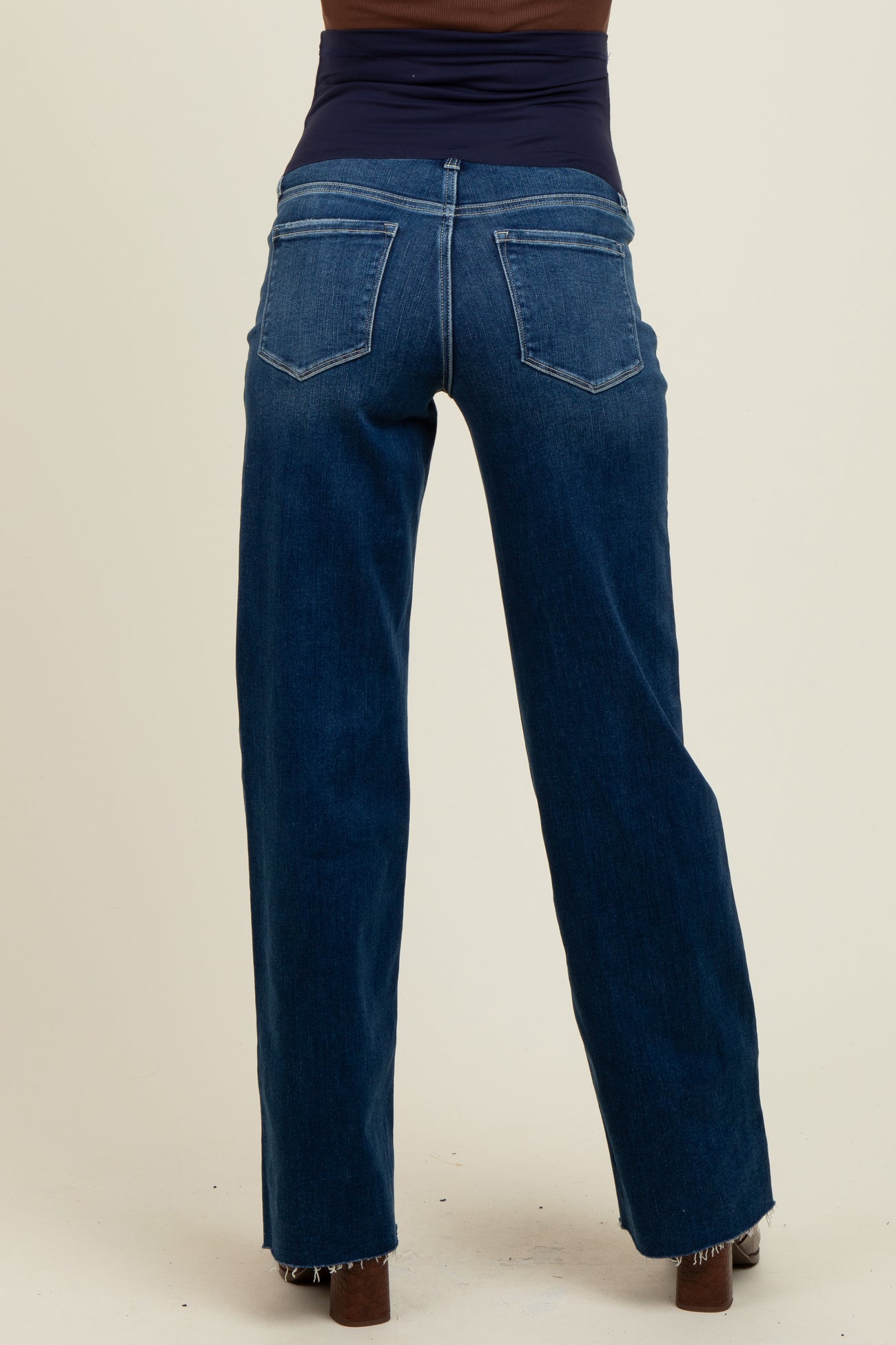 woman wearing dark blue maternity jeans viewed from the back, showing a relaxed fit and wide legs
