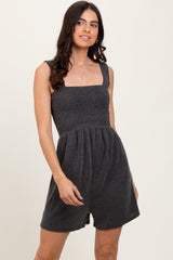 woman wearing a black striped smocked romper with square neckline and relaxed fit shorts