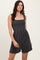 woman wearing a black striped smocked romper with square neckline and relaxed fit shorts