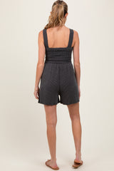 woman wearing a black striped maternity romper with a fitted bodice and loose shorts, seen from the back