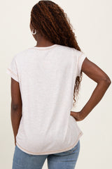woman wearing a light pink short sleeve top viewed from the back with rolled cuffs, paired with blue jeans
