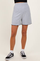 woman wearing light gray ribbed shorts with scalloped hem and black athletic shoes