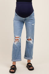 woman wearing distressed light blue maternity jeans with a visible baby bump and rolled cuffs