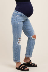 woman wearing distressed light blue maternity jeans with a black top and a visible baby bump