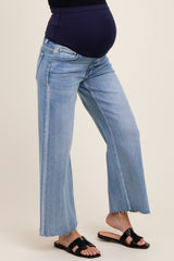 woman wearing light blue maternity wide-leg jeans with a frayed hem and a visible baby bump