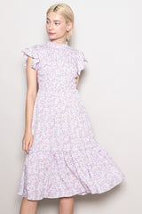 woman wearing a lavender floral midi dress with ruffled sleeves and a tiered skirt