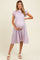 woman wearing a lavender floral maternity dress with puff sleeves and a ruffled hem, holding her baby bump