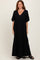 woman wearing a black maxi dress with a v-neckline, puff sleeves, and button details