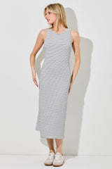 woman wearing a sleeveless black and white striped midi dress with a relaxed fit and sneakers