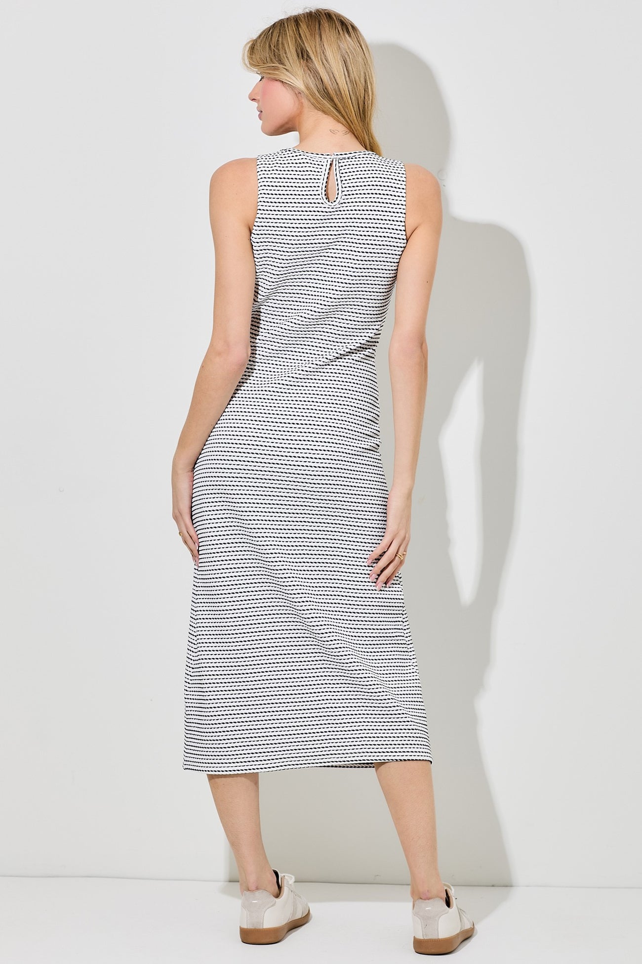 woman wearing a black and white checkered midi dress with a keyhole detail at the back
